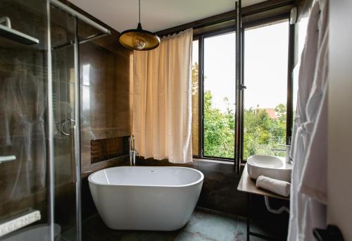 a bathroom with a large tub and a sink at AUTOGRAPH Kutaisi in Kutaisi