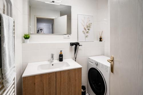 a bathroom with a sink and a washing machine at Gemütliche Wohnung am Bodensee - Self-CheckIn in Markdorf
