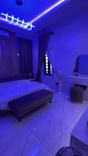 a bedroom with a bed with purple lights on it at Greenwich Garden in Onisigun