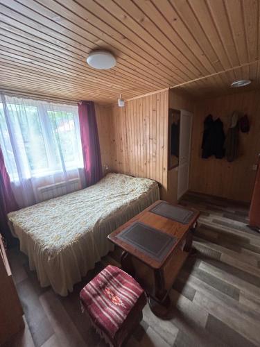 a small bedroom with a bed and a table at Смарт-Квартира in Yaremche