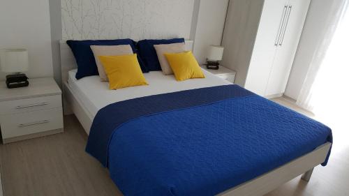 1 dormitorio con 1 cama con almohadas azules y amarillas en Apartments Teo, en Hvar