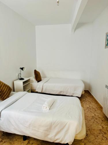 two beds in a room with white walls at Fórmula 1 aeropuerto in Madrid