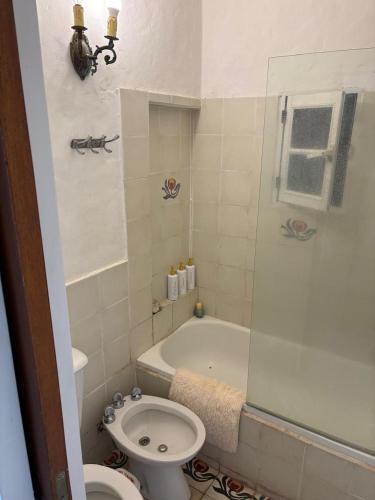 a bathroom with a toilet and a tub and a sink at Casa de Barro in Junín