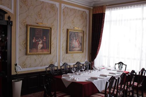 a dining room with a long table and chairs at Kaiser Hotel in Chernivtsi