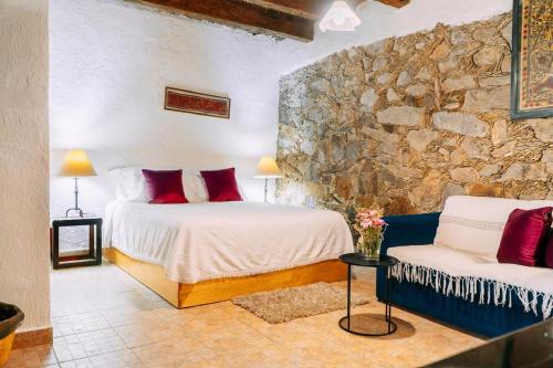 a bedroom with two beds and a stone wall at Hotel Boutique Morada De Paz in Real de Catorce