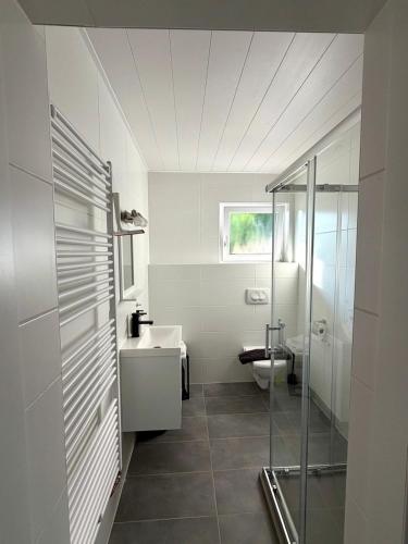 a white bathroom with a sink and a toilet at Gästehaus Talblick Baiersbronn in Baiersbronn