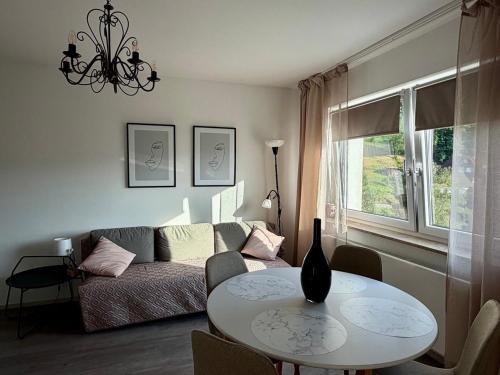 a living room with a table and a couch at Gästehaus Talblick Baiersbronn in Baiersbronn