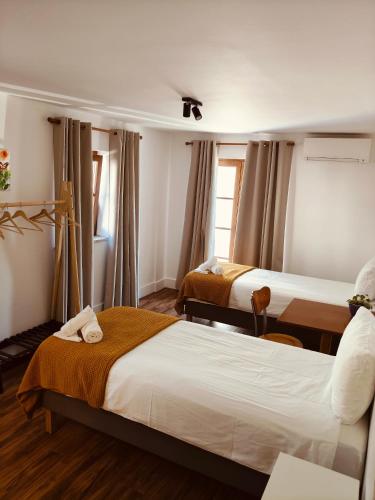 a hotel room with two beds and a window at Casa Fidal in Bordeira
