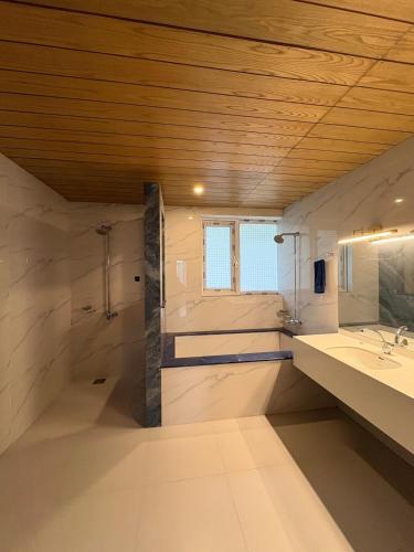 a large bathroom with a sink and a mirror at The Elysian Villa in Murree