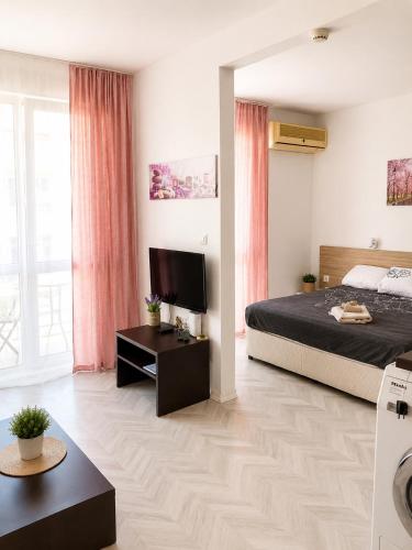 a bedroom with a large bed and a television at Bellissima Studio Sarafovo е вашият уютен дом само на 3 минути от плажа in Burgas
