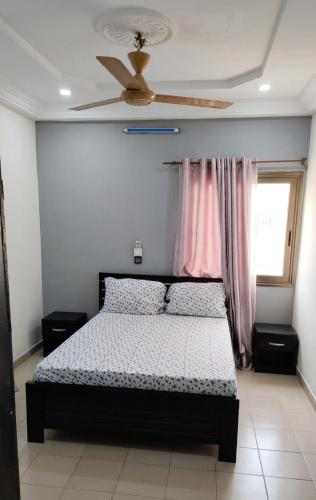 a bedroom with a bed and a ceiling fan at BKSF Wemtenga 1 in Ouagadougou