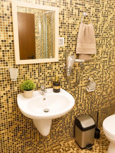 a bathroom with a sink and a mirror and a toilet at Bellissima Studio Sarafovo е вашият уютен дом само на 3 минути от плажа in Burgas
