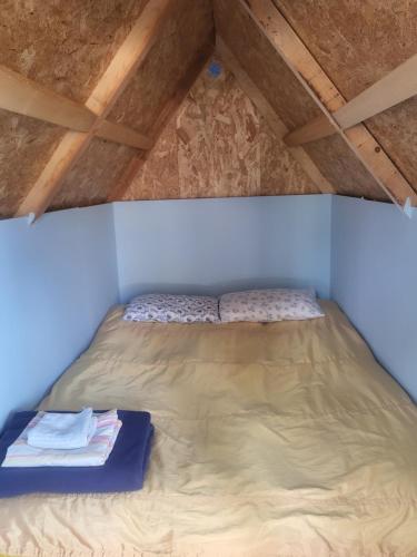 a bed in a room with a wooden ceiling at Micro Africa Camping Site in Delvinë