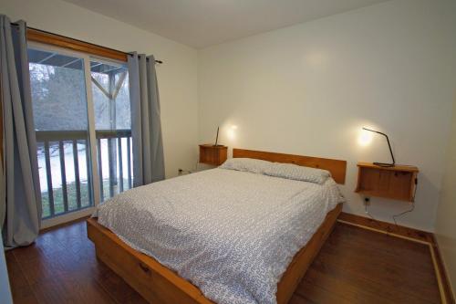 um quarto com uma cama e uma grande janela em Summit Ridge 5 em Blue Mountains