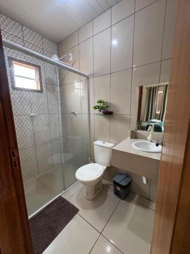 a bathroom with a toilet and a shower and a sink at Solar DorisMar in Luis Correia