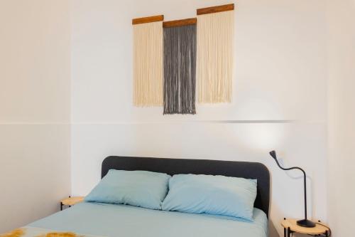 a bed with a blue pillow and a lamp at Casa Limão in Charneca