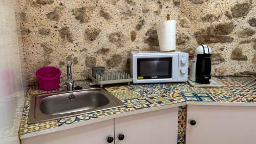 a kitchen counter with a sink and a microwave at Casa Boutique Margarita in Peniscola