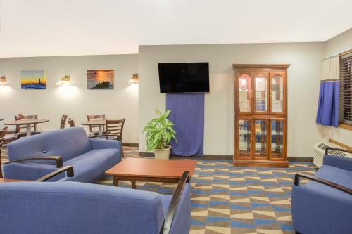 a waiting room with blue chairs and a table at Microtel Inn and Suites Manistee in Manistee