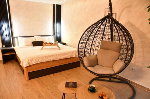 a room with a bed and a hanging chair at Politon Suites in Zaječar