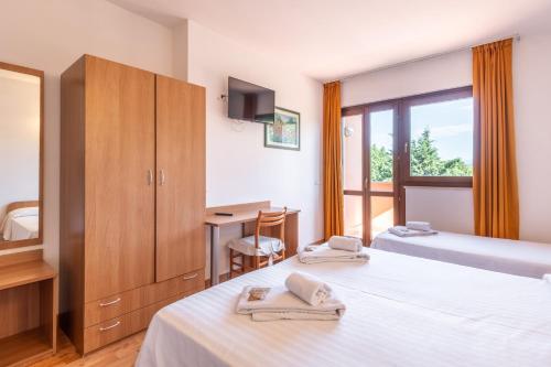 a hotel room with two beds and a window at Hotel La Carica in Pastrengo