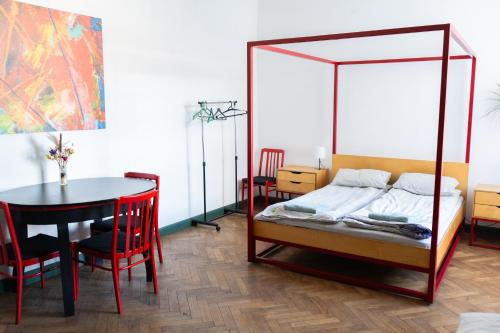 a bedroom with a bed and a table and chairs at Coffee Home Hostel in Lviv