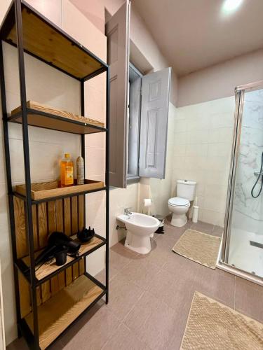 a bathroom with a toilet and a glass shower at Spacious T4 Central Apartment with Iconic Tram 28 View in Lisbon