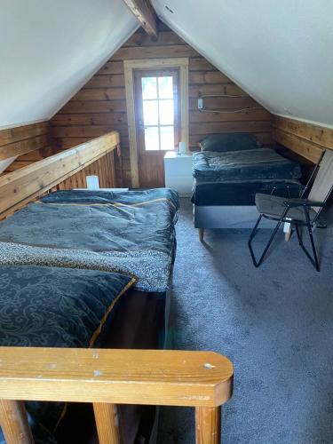 a attic room with three beds and a chair at Haus der Sinne in Buddenhagen