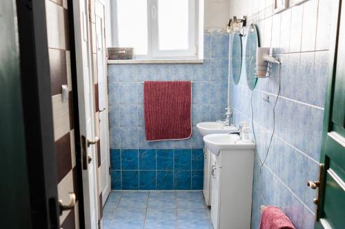 a blue tiled bathroom with a red towel and a sink at Coffee Home Hostel in Lviv