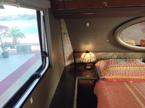 a bedroom with a bed and a window with a view at Caravan with private toilet and kitchen 2 in Grebaštica