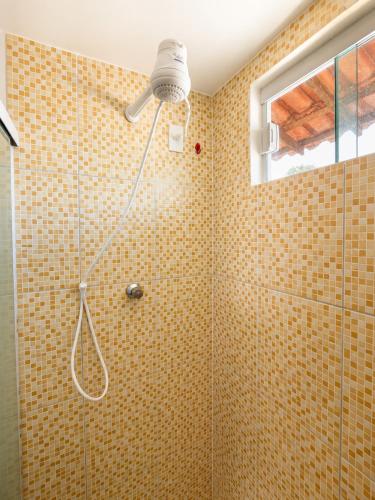 a shower with a shower head in a bathroom at Atins Suites in Atins