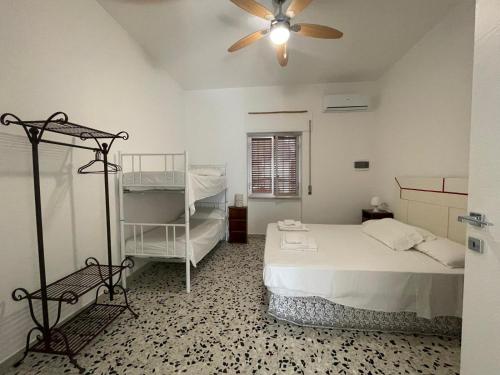 a bedroom with a bed and a ceiling fan at B&B Al Vecchio Glicine in Torre Canne