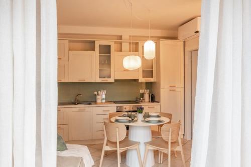 a kitchen with a table and chairs and a kitchen with white cabinets at Luxury Garden Suite with Private Heated jacuzzi in Perugia