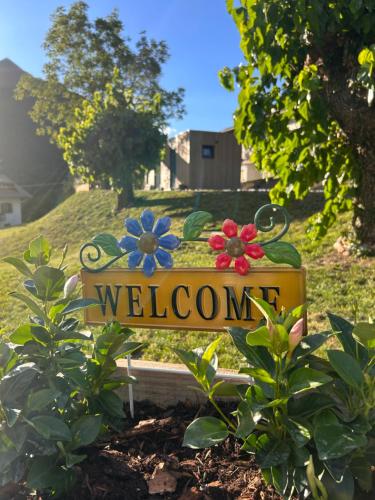 a welcome sign in a garden with flowers on it at Everest Experience in Paluzza