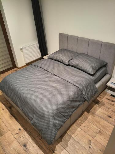 a bed in a room with a gray bed frame at Apartament Matki Polki II in Łódź