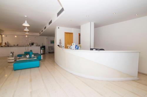 a lobby of a clinic with a white counter and blue tables at Grand Boutique in Vasiliki