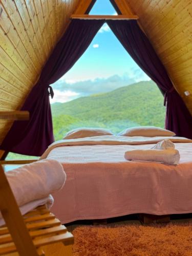 a bed in a room with a view of a window at Mtis qokhi Twins in Mtskheta