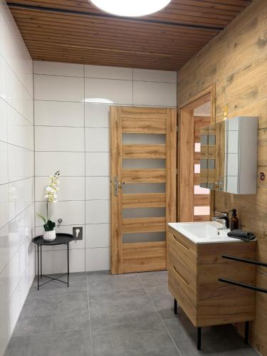 a bathroom with a sink and a wooden door at Patrycja 2 Top 1 in Ehenbichl