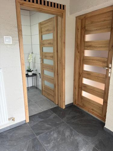 two wooden doors in a room with a tile floor at Patrycja 2 Top 1 in Ehenbichl