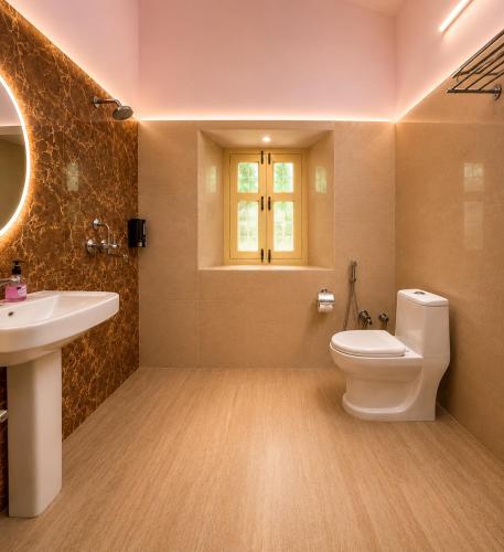 a bathroom with a toilet and a sink and a window at Doi Stays Dak Bungalow in Almora
