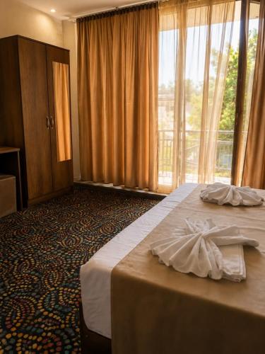 a hotel room with a bed and a large window at Hotel Kopala Ureki in Ureki