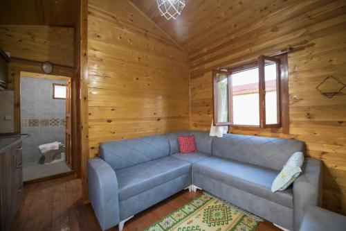 a living room with a couch in a log cabin at Kozalak Bungalows in Çaykenarı