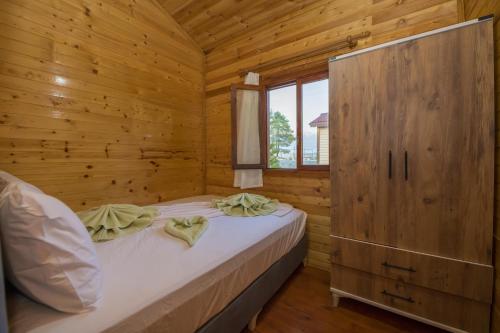 a bedroom with a bed in a wooden cabin at Kozalak Bungalows in Çaykenarı