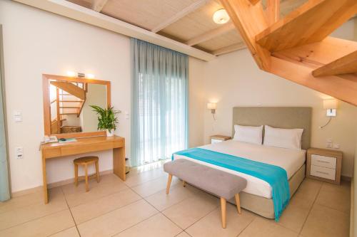 a bedroom with a bed and a desk and a mirror at Grand Boutique in Vasiliki