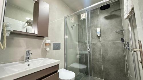 a bathroom with a shower and a sink and a toilet at AZAK BLUE OTEL in Okurcalar