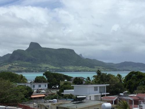 a view of a town with mountains and a body of water at Orient Guesthouse Auberge in Mahébourg