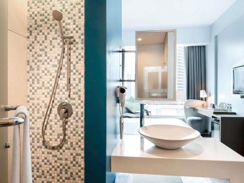 a bathroom with a shower and a toilet in it at All Seasons Jakarta Thamrin in Jakarta