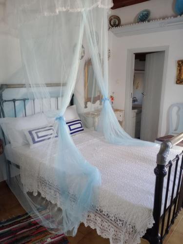a bedroom with a bed with a canopy at Nyfes Traditional Boutique Vagelio in Skiros