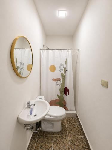 a bathroom with a toilet and a sink and a mirror at Hotel Castillo in San Pedro Sula