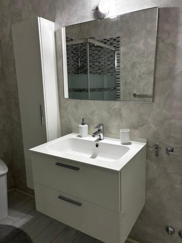 a bathroom with a white sink and a mirror at Pop Art Apartament in Treviso