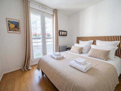 a bedroom with a large bed with two towels on it at Paris Bercy with car park by Melvane in Charenton-le-Pont